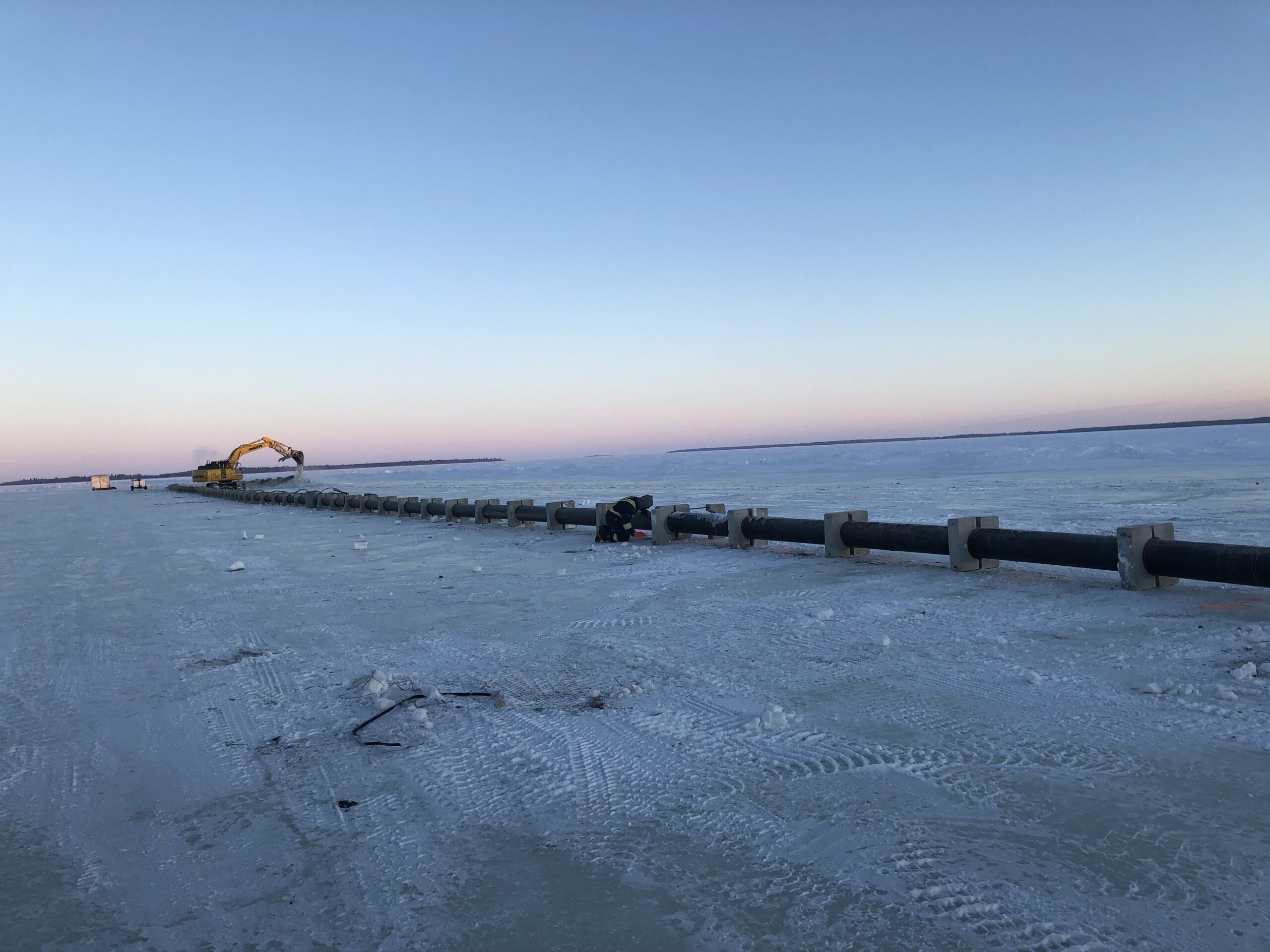 A water intake pipeline weighted and laid out on the ice.
