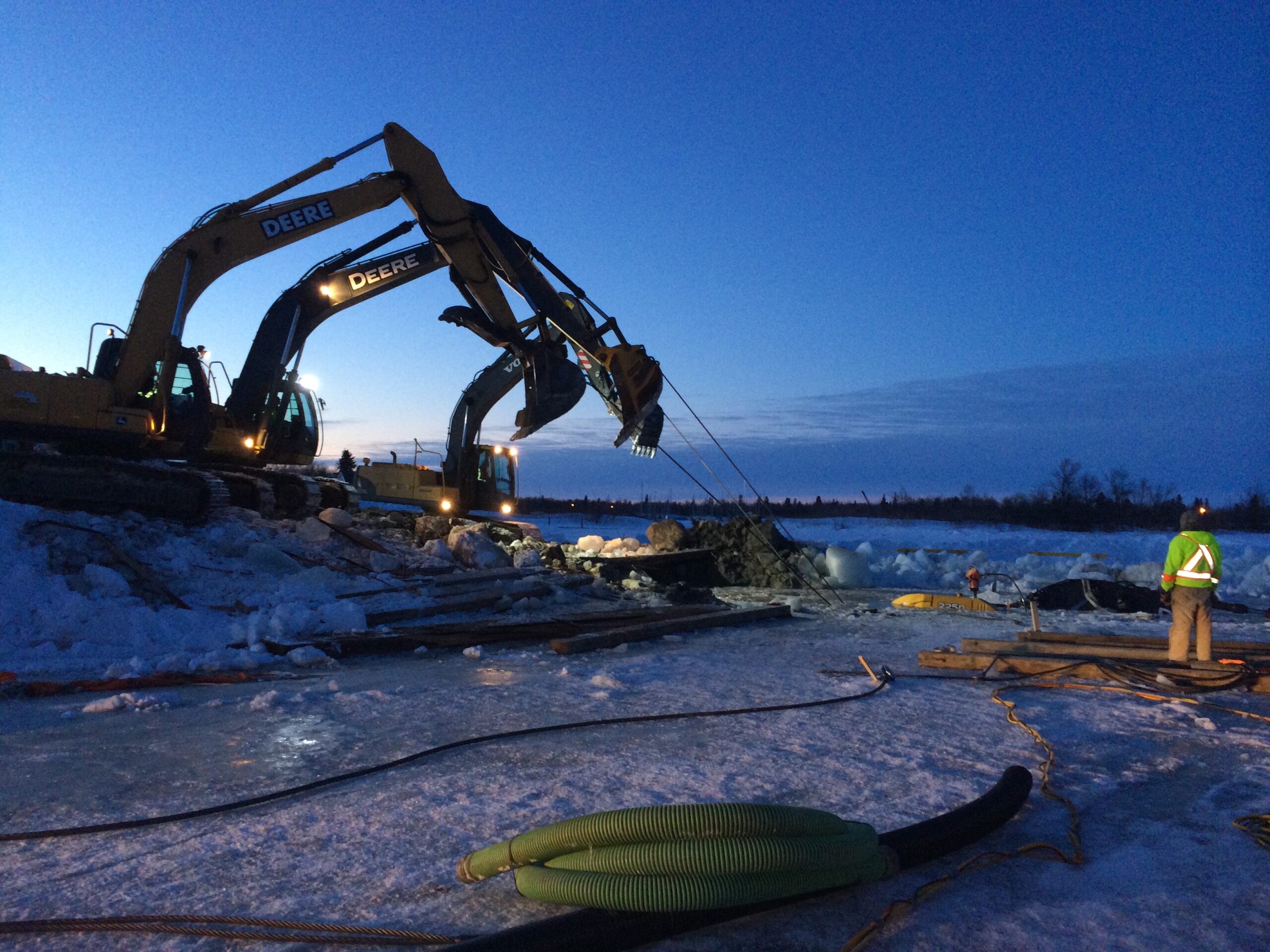 Pulling excavator from water.
